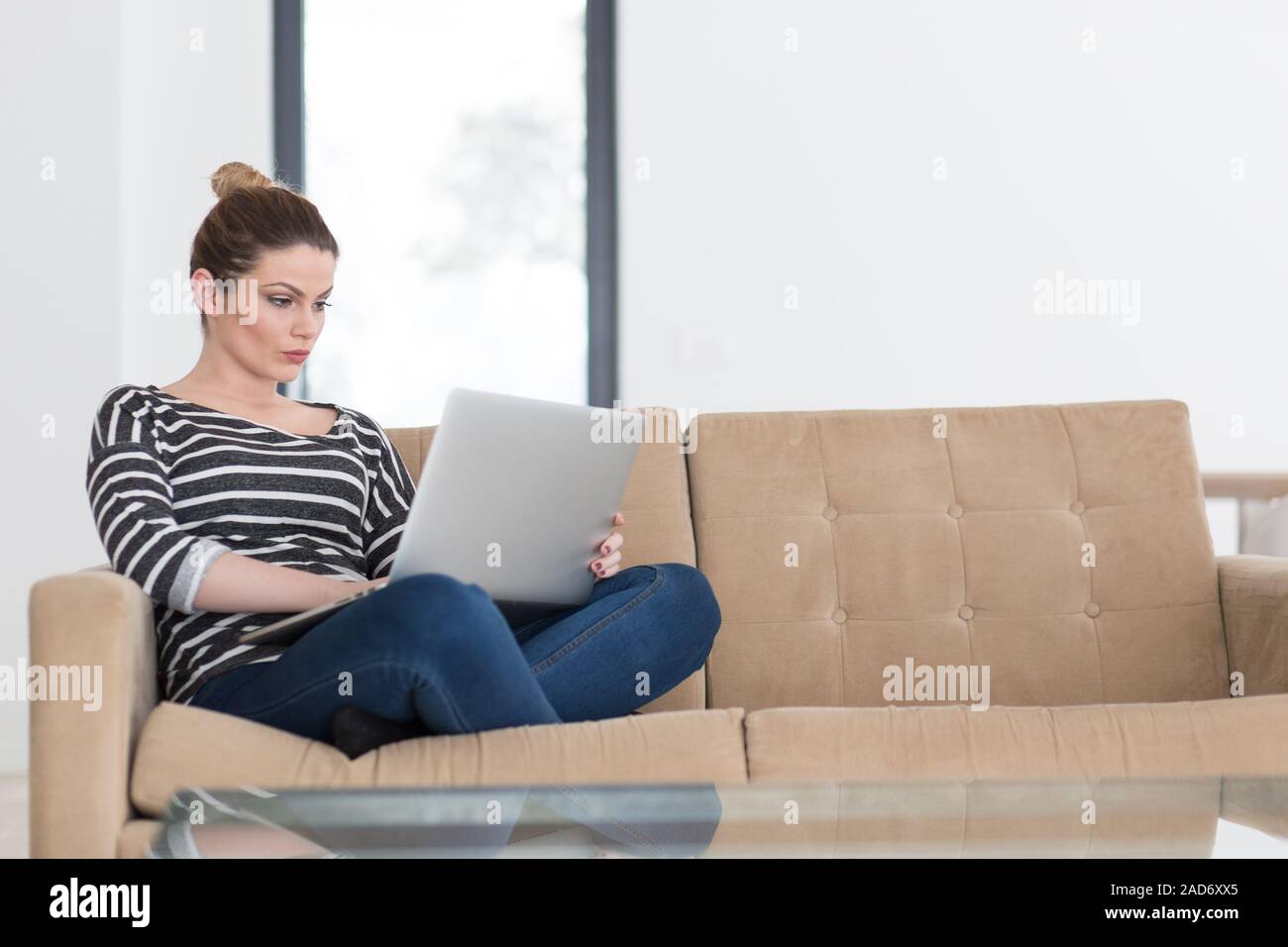 Junge Frau auf dem Sofa zu Hause surfen Stockfoto