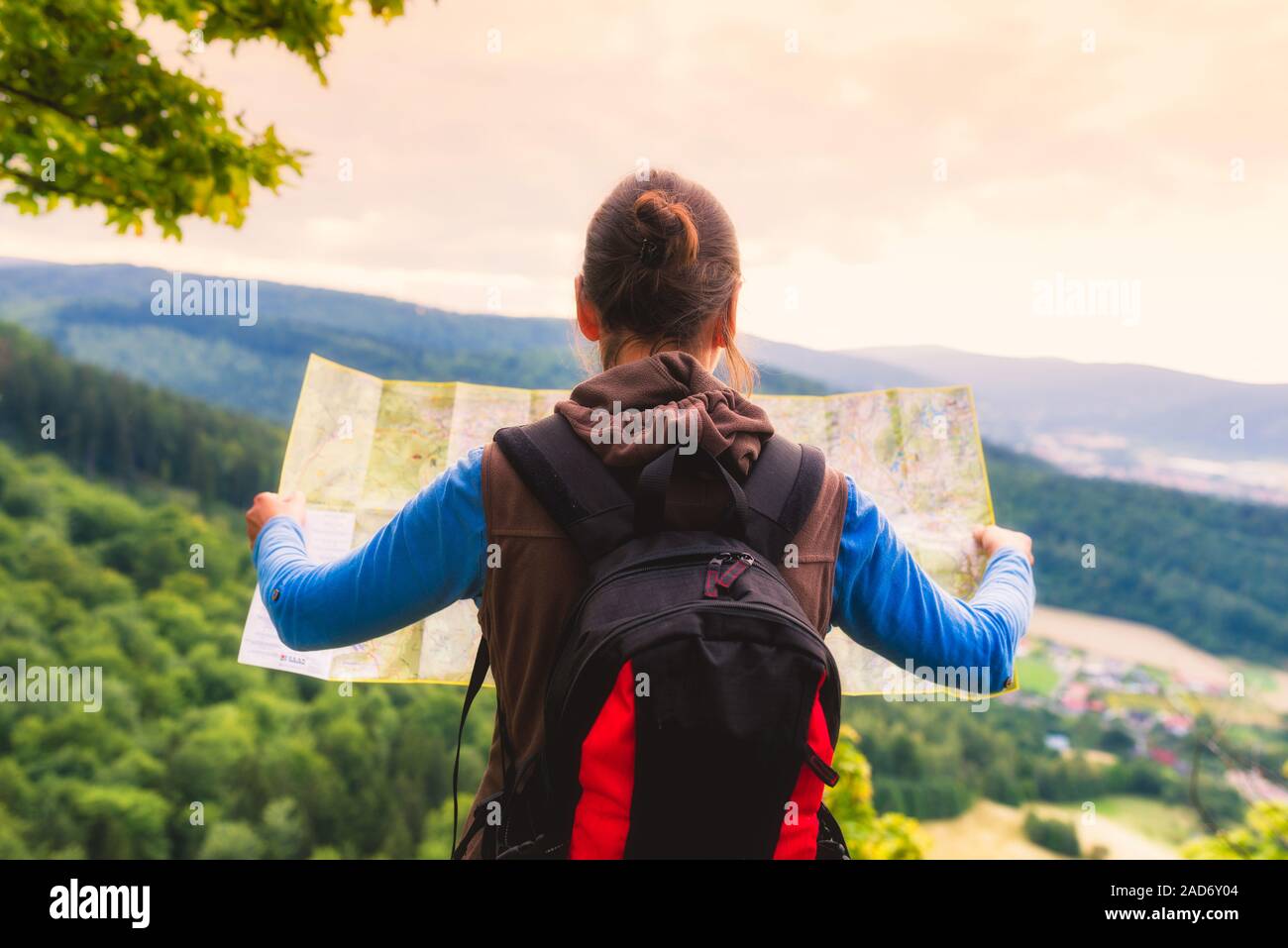 Frau Reisenden mit Rucksack Kontrollen Karte Richtungen in der Wildnis, echten Explorer finden. Travel Concept Stockfoto