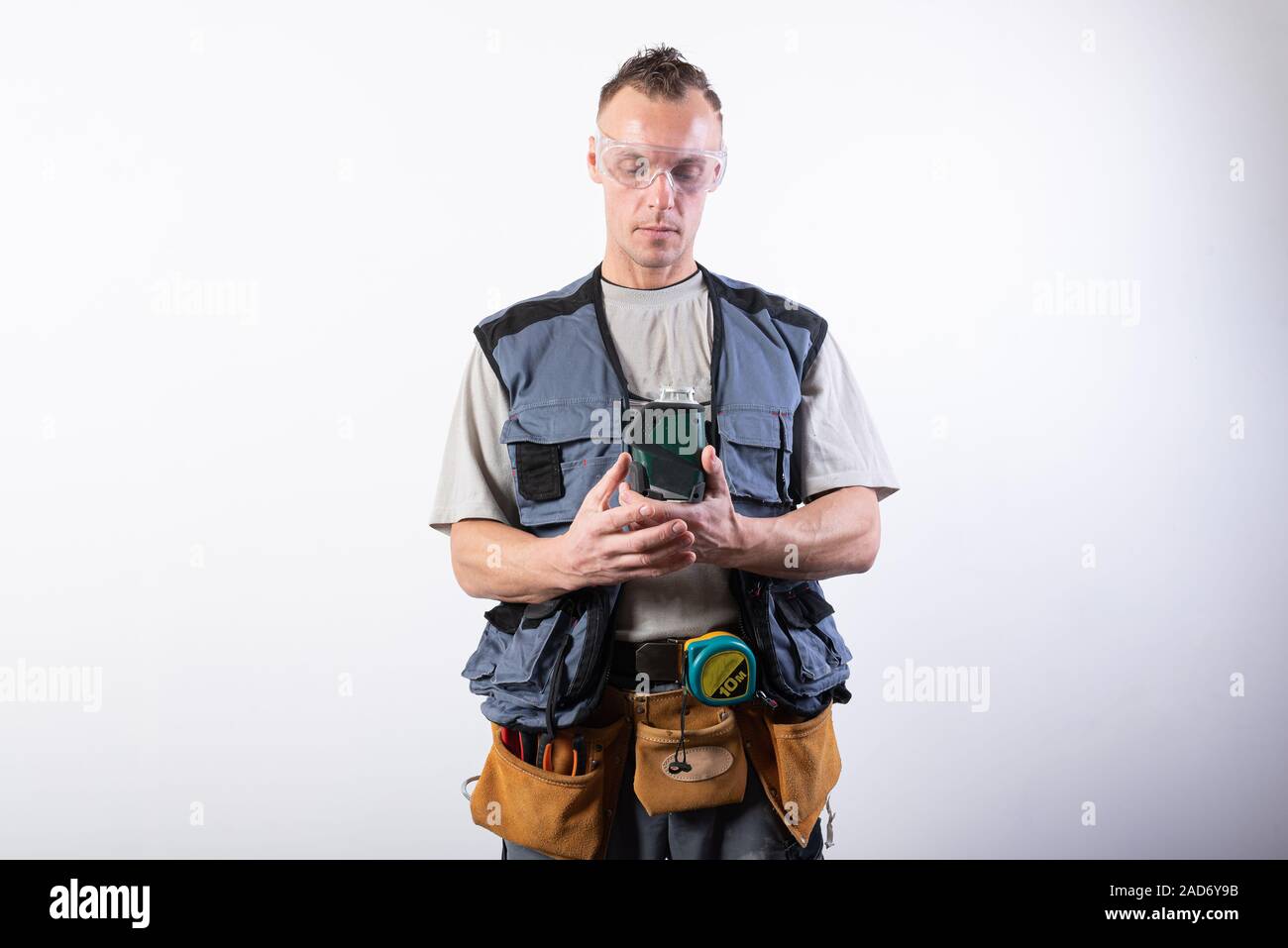 Builder in entladen, mit einem Laser. Auf einem hellen Hintergrund. Stockfoto