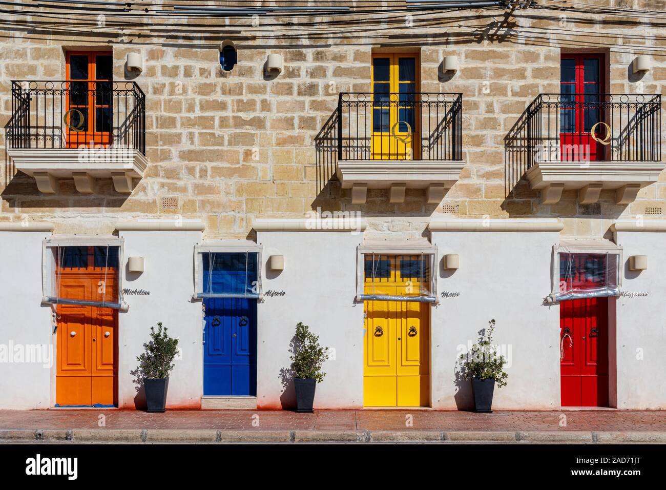 Ferienwohnung im Fischerdorf Marsaxlokk, Malta. Die Wohnungen sind hell vordere Türen und Balkone gestrichen. Stockfoto