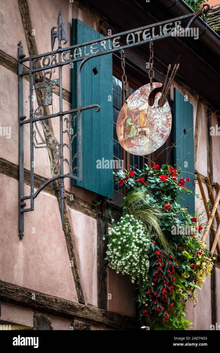 Atemberaubende Riquewihr Fenster und Boutique Anmelden Stockfoto