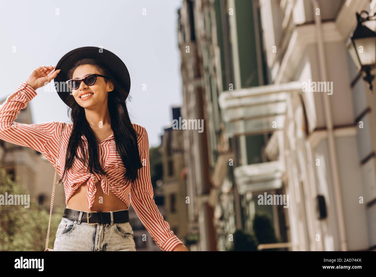 Glückliche Frau an einem sonnigen Tag auf der Straße Foto Stockfoto