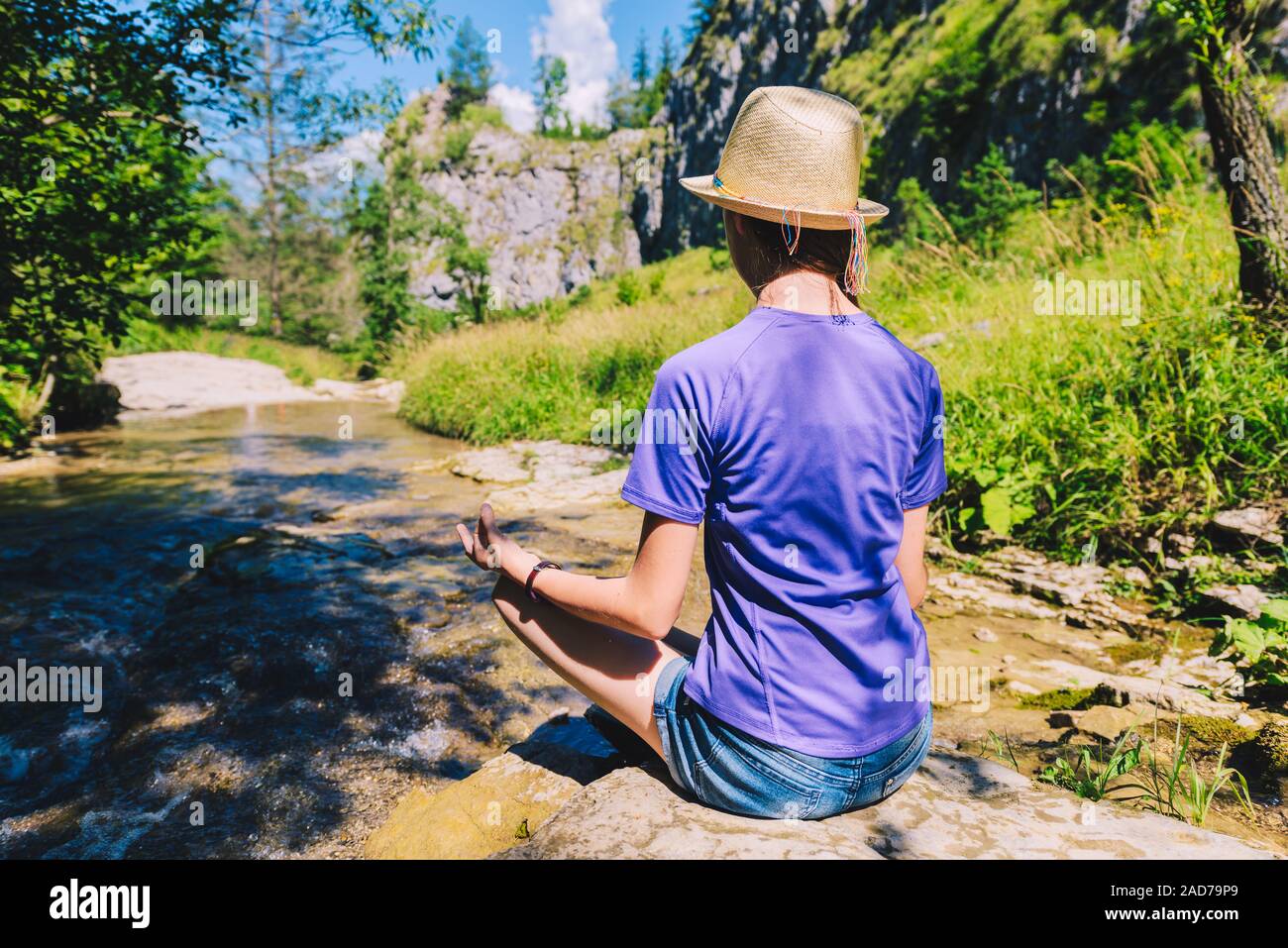 Junge Frau, meditieren, Yoga Pose an einem Bergbach Stockfoto