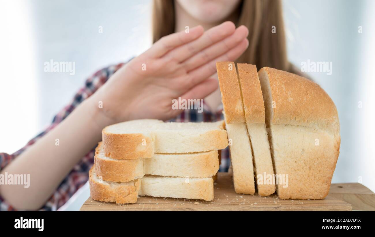 Glutenintoleranz Konzept. Junge Mädchen sich weigert, weißes Brot - geringe Tiefenschärfe zu essen Stockfoto