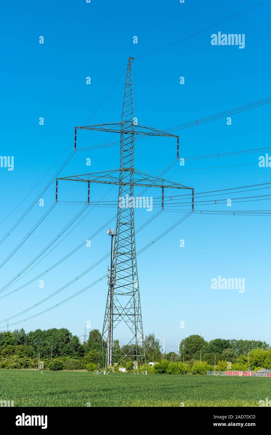 Stromleitungen und elektrischen Masten auf einem sonnigen Tag in Deutschland gesehen Stockfoto