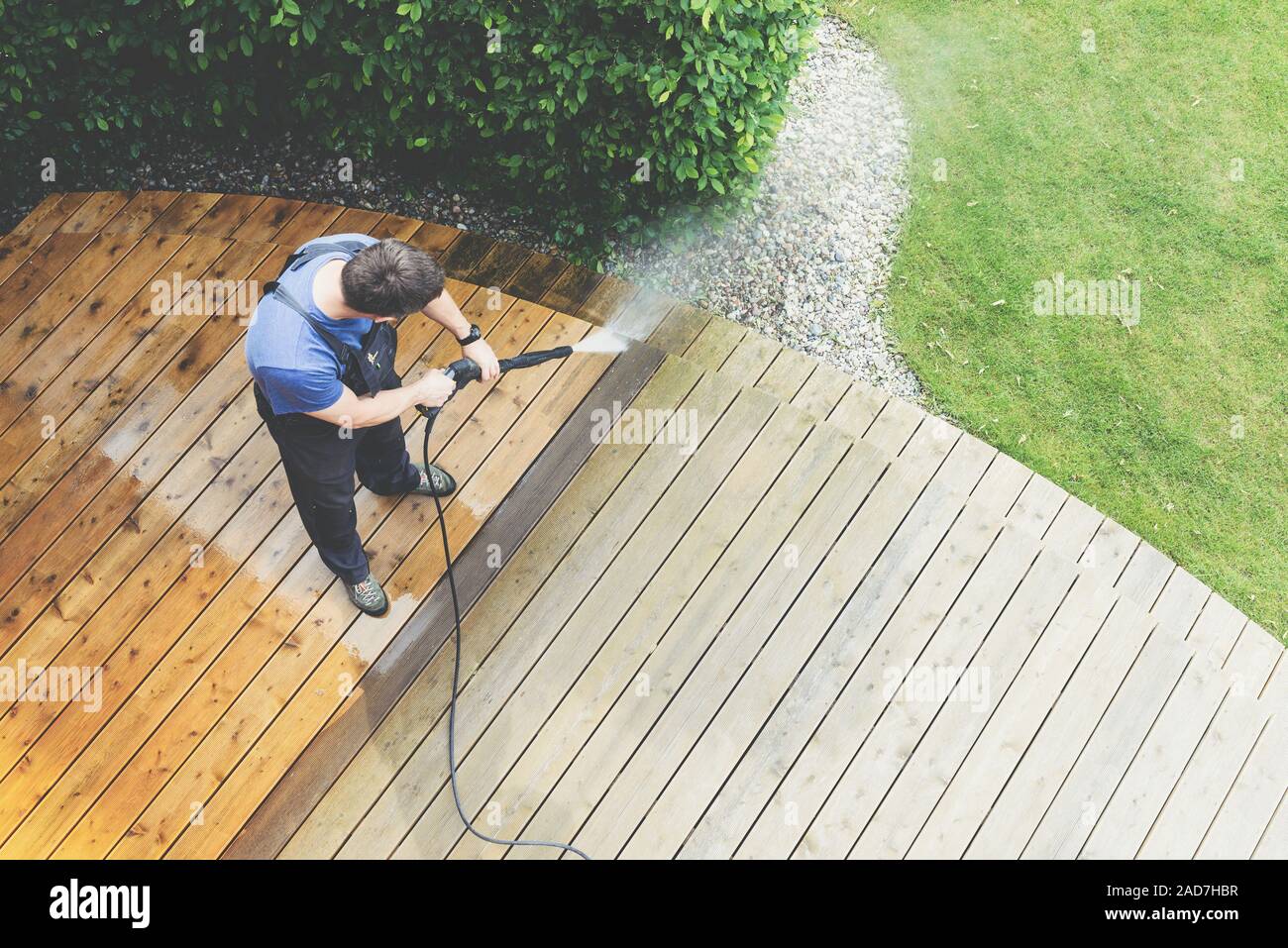 Reinigung Terrasse mit einen Hochdruckreiniger - Hochwasser Hochdruckreiniger auf Holzterrasse Oberfläche Stockfoto