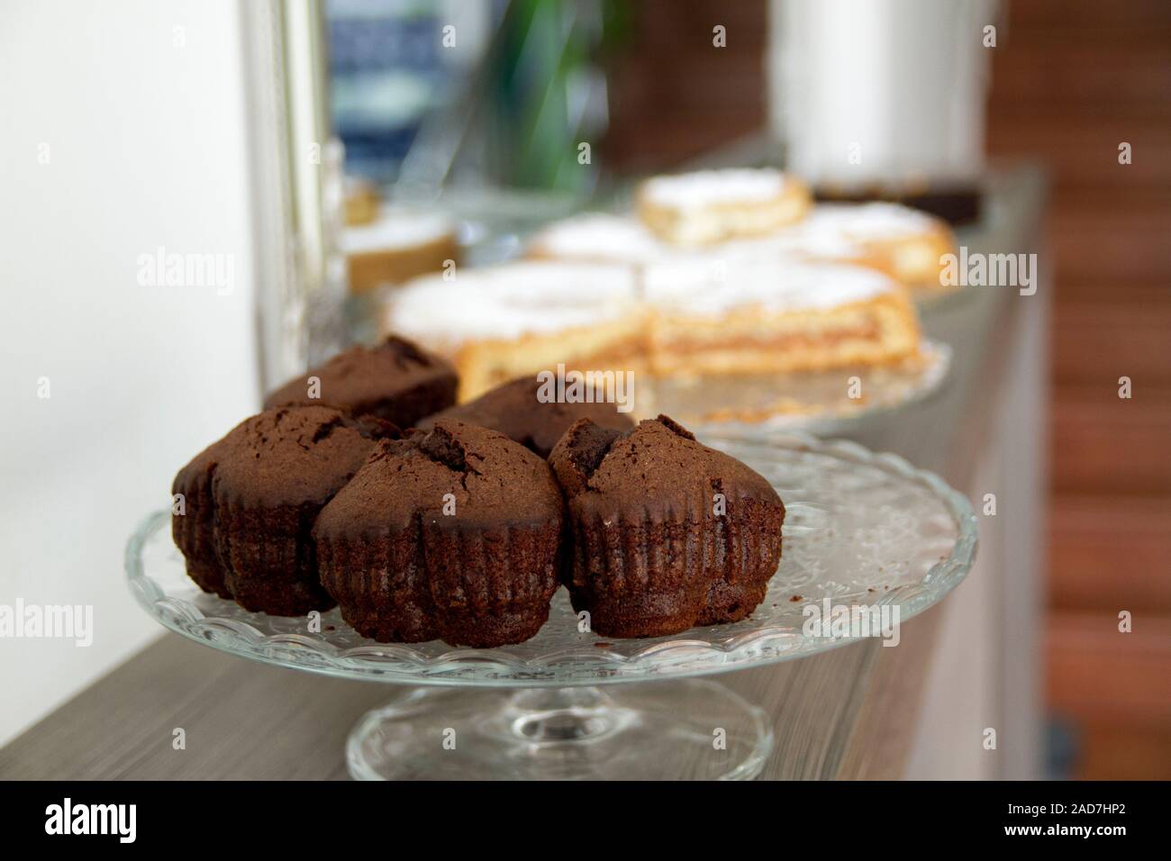 Schokolade in Herzform Muffins auf einem Glas Kuchen stehen mit unscharfen Apple Pies in den Hintergrund. Stockfoto