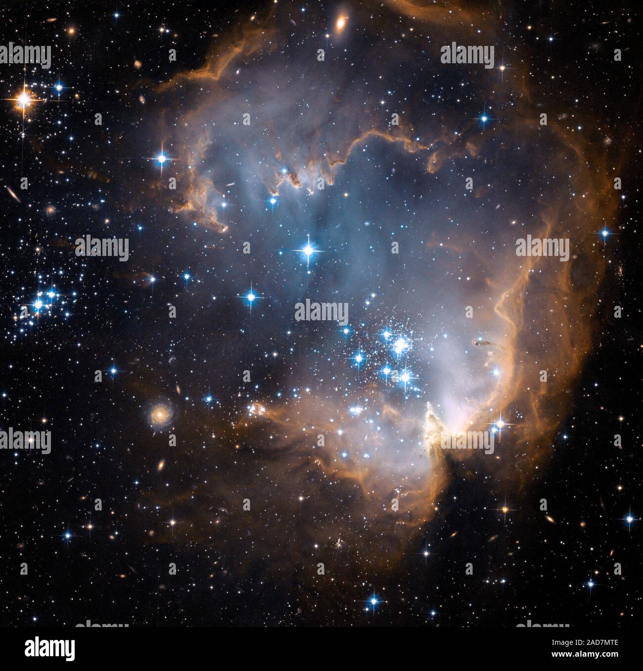 Dieses neue Bild mit dem NASA-Hubble-Weltraumteleskop genommen zeigt helle, blau, neu gebildeten Sterne, die einen Hohlraum in der Mitte der Sterne Blasen-forming Region in der Kleinen Magellanschen Wolke. Im Herzen der Sternentstehungsregion, liegt Sternhaufen NGC 602. Die energiereiche Strahlung blazing aus der heiße junge Sterne ist Sculpting die innere Kante des äußeren Teile des Nebels, langsam erodieren und Essen in das Material darüber hinaus. Die diffuse äußeren Reichweiten des Nebels verhindern die energetische Abflüsse aus vom Cluster streaming. Kanten von Staub- und gasförmigen Filamente Stockfoto
