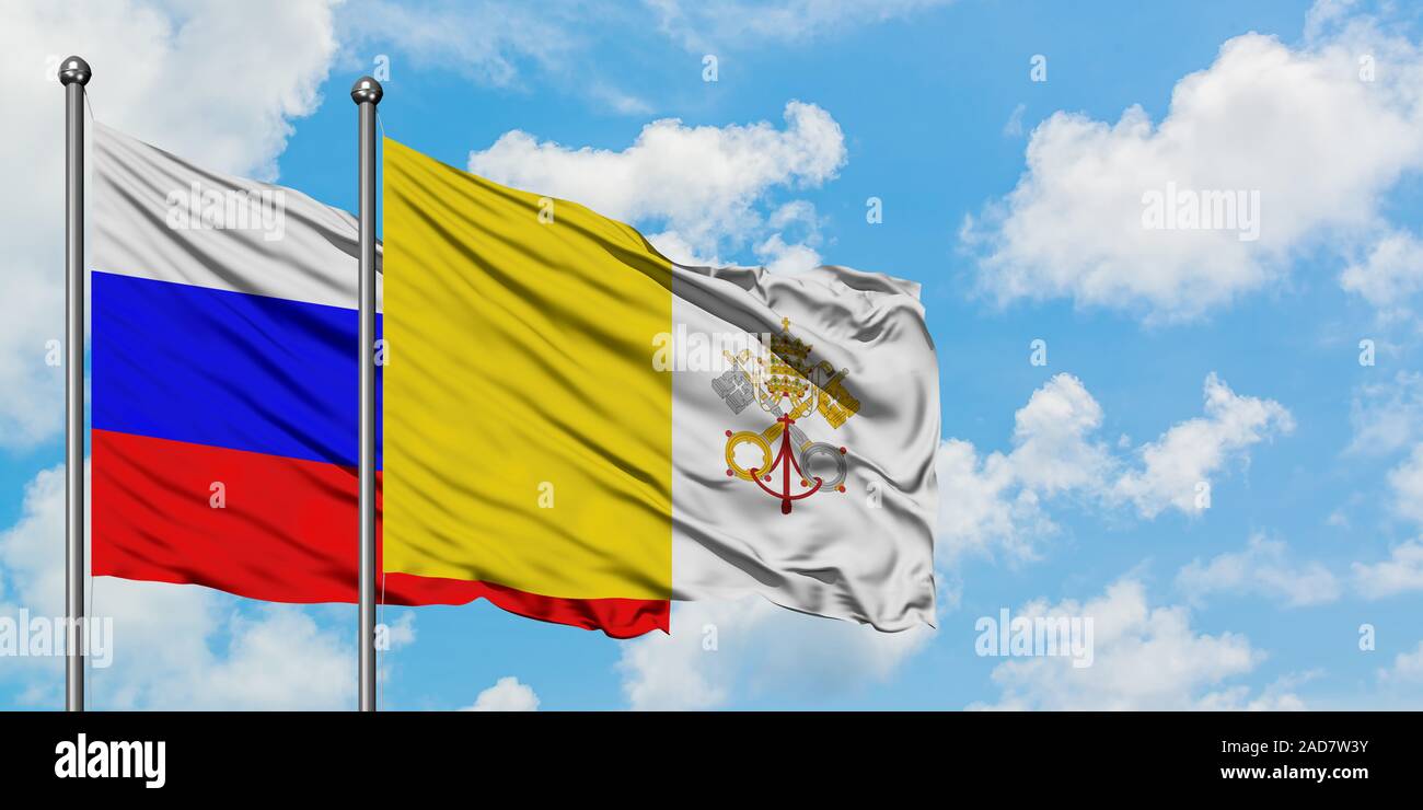 Russland und Vatikanstadt Flagge im Wind gegen Weiße bewölkt blauer Himmel zusammen. Diplomatie Konzept, internationale Beziehungen. Stockfoto