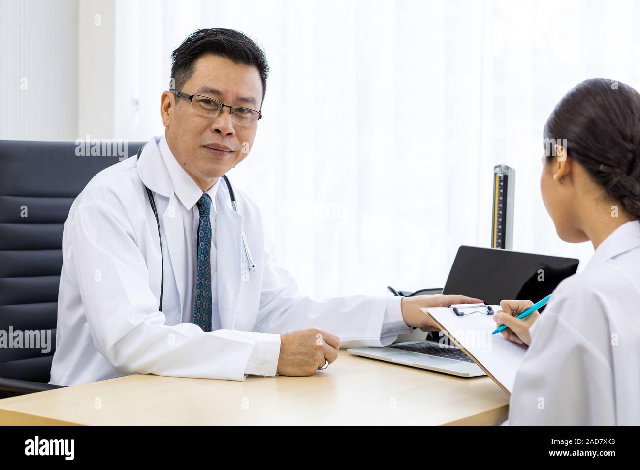 Zwei Ärzte im Krankenhaus die Diagnos des Patienten besprechen Stockfoto