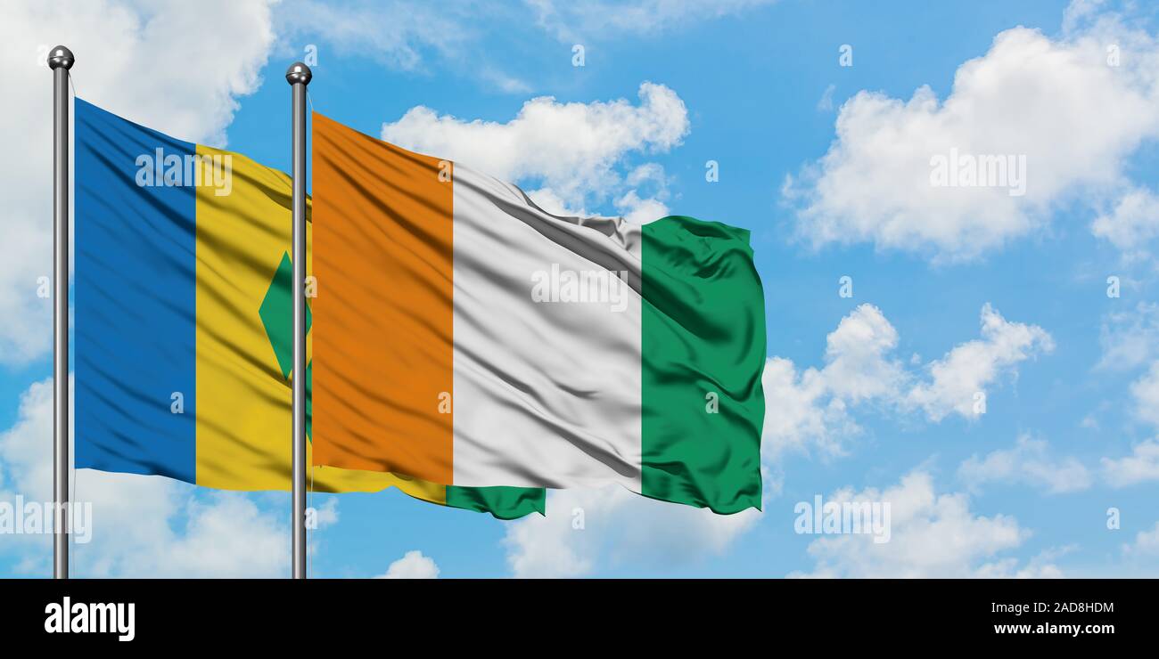 Saint Vincent und die Grenadinen und Côte d'Ivoire Fahne im Wind gegen Weiße bewölkt blauer Himmel zusammen. Diplomatie Konzept, internationale re Stockfoto