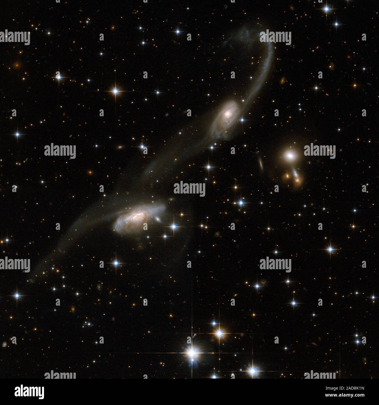 Die Galaxien dieser schönen Interaktion Paar tragen einige Ähnlichkeit mit Noten auf einer Daube. Lange tidal tails Sweep aus den beiden Galaxien: Gas und Sterne waren abgenutzt und weg von den äußeren Regionen der Galaxien hin und her gerissen. Das Vorhandensein dieser Schwanz ist die eindeutige Signatur einer Interaktion. ESO 69-6 ist im Sternbild Triangulum Australe, die Südliche Dreieck, etwa 650 Millionen Lichtjahre von der Erde entfernt. Dieses Bild ist Teil einer großen Sammlung von 59 Bildern der verschmelzenden Galaxien, die das Hubble-Weltraumteleskop aufgenommen und anlässlich seines 18. annive freigegeben Stockfoto