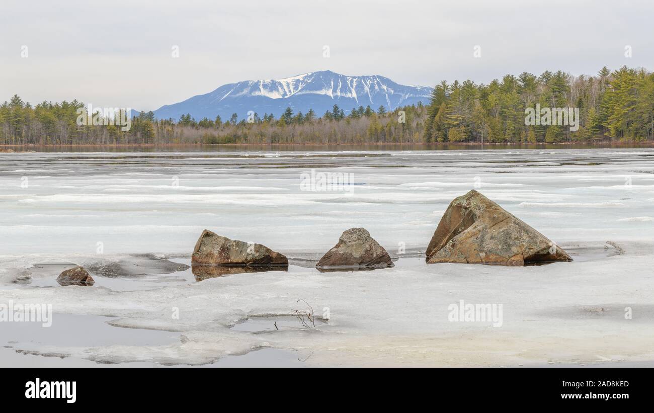 Katahdin hinter einem gefrorenen Teich mit gezackten Felsen im Vordergrund. Stockfoto