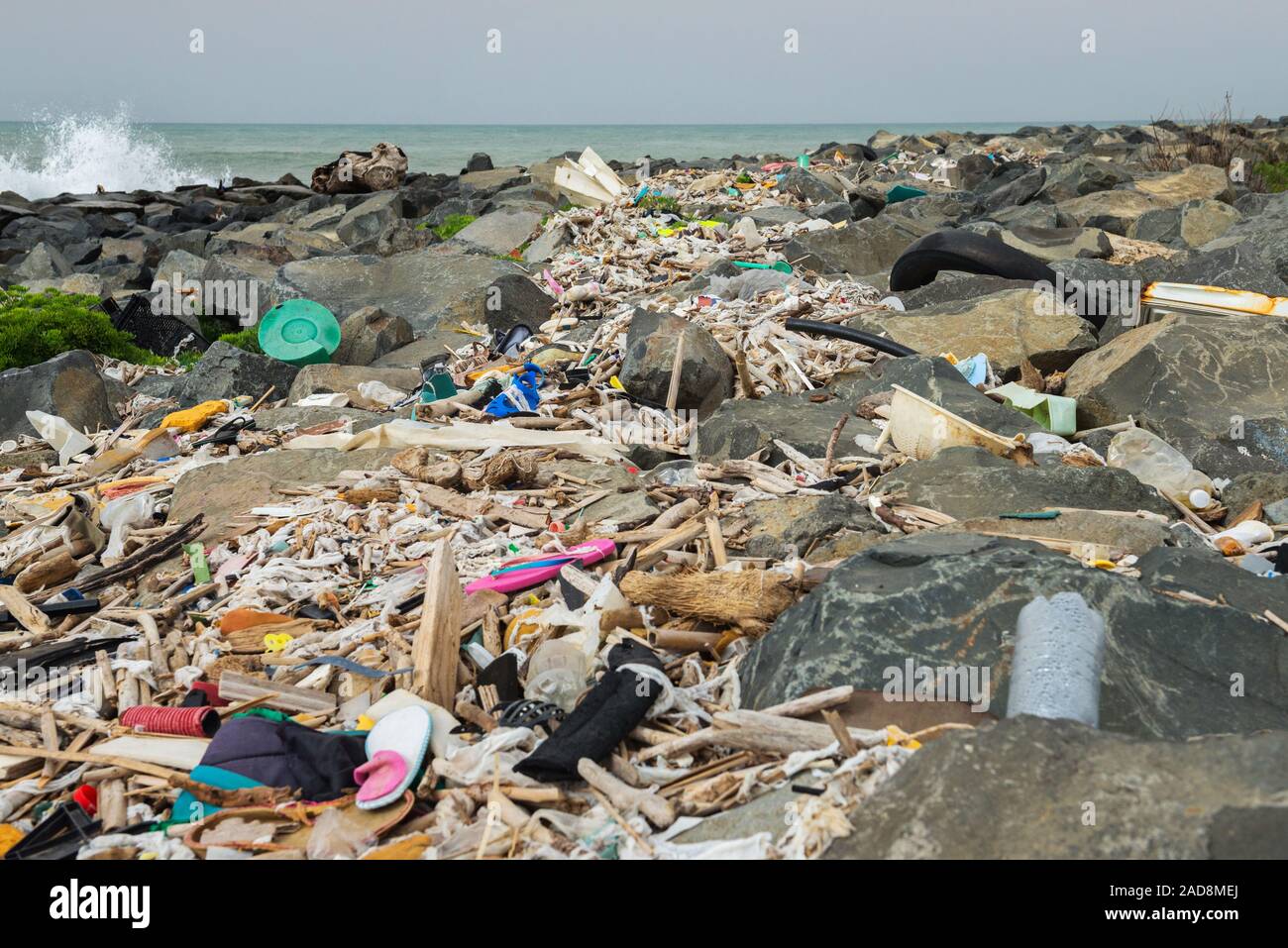 Verschüttete Müll am Strand in der Nähe der großen Stadt. Leere benutzten schmutzige Plastikflaschen und anderen Müll. Stockfoto