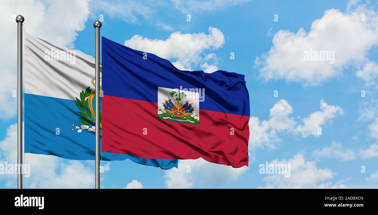 San Marino und Haiti Flagge im Wind gegen Weiße bewölkt blauer Himmel zusammen. Diplomatie Konzept, internationale Beziehungen. Stockfoto