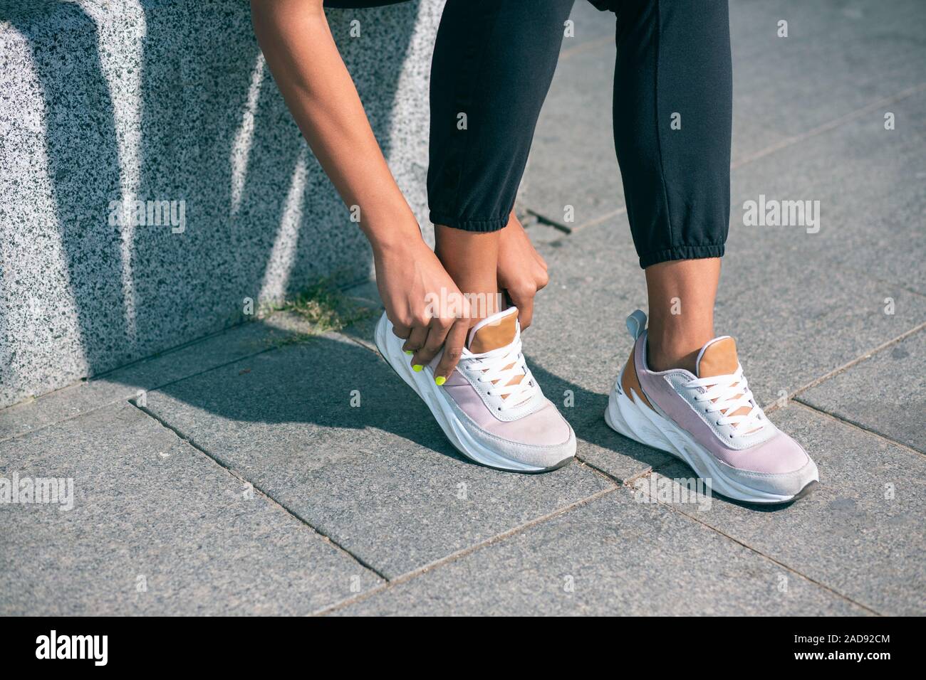 Beine und Frau berühren sneakers Foto Stockfoto