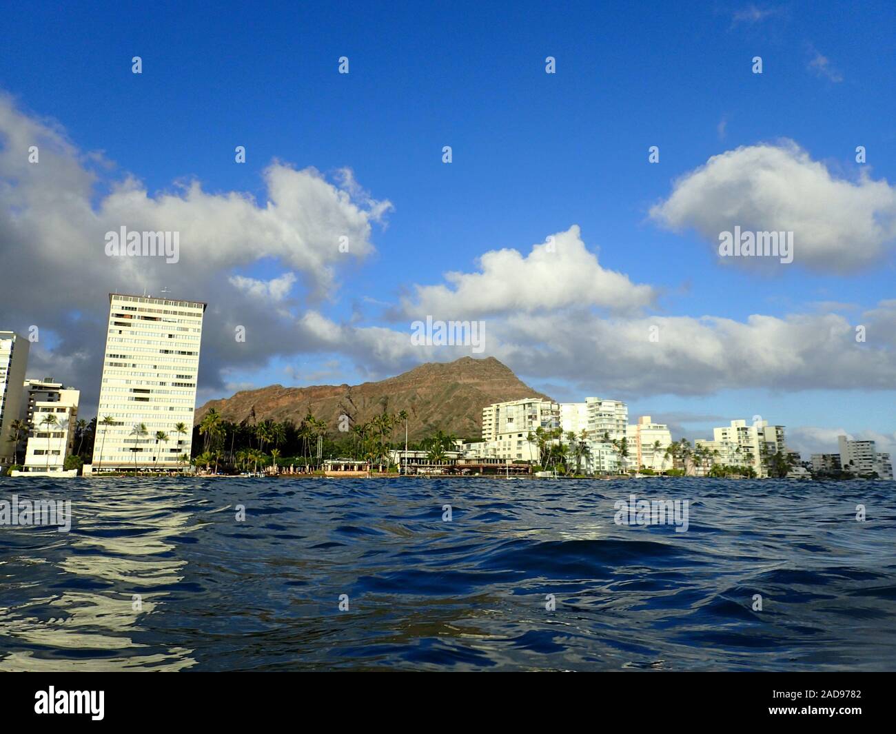 Hotel Outrigger Canoe Club, Kokospalmen, Condo Gebäude, Wolken und Diamond Head Krater in der Ferne auf Oahu, Hawaii gesehen von der Stockfoto