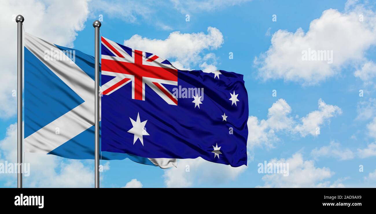 Schottland und Australien Flagge im Wind gegen Weiße bewölkt blauer Himmel zusammen. Diplomatie Konzept, internationale Beziehungen. Stockfoto