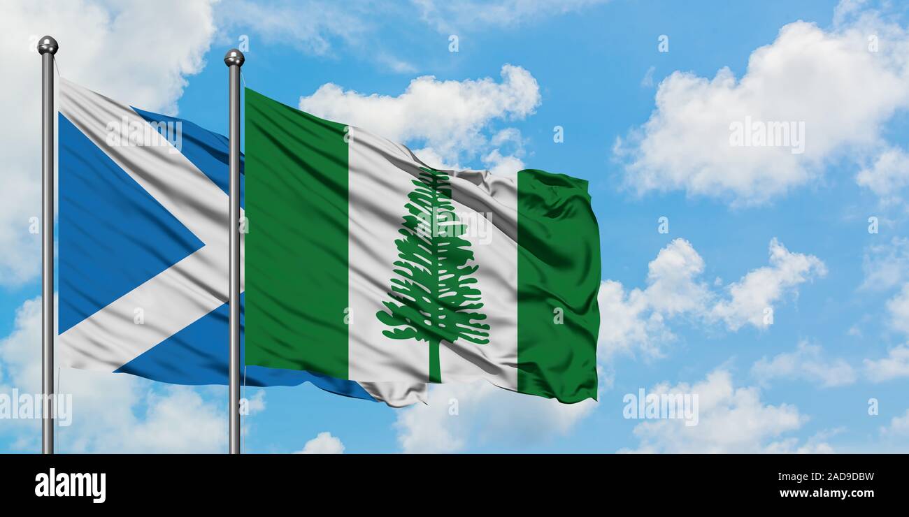 Schottland und Norfolk Island Flagge im Wind gegen Weiße bewölkt blauer Himmel zusammen. Diplomatie Konzept, internationale Beziehungen. Stockfoto