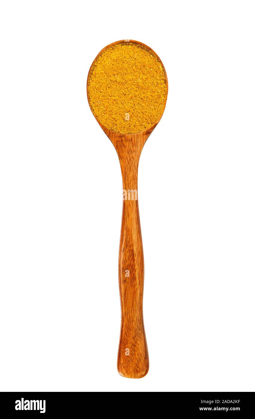 Curry in einem Kochlöffel zu isolieren. Gewürz auf isolieren. Blick von oben. Trockene Gewürze. Stockfoto
