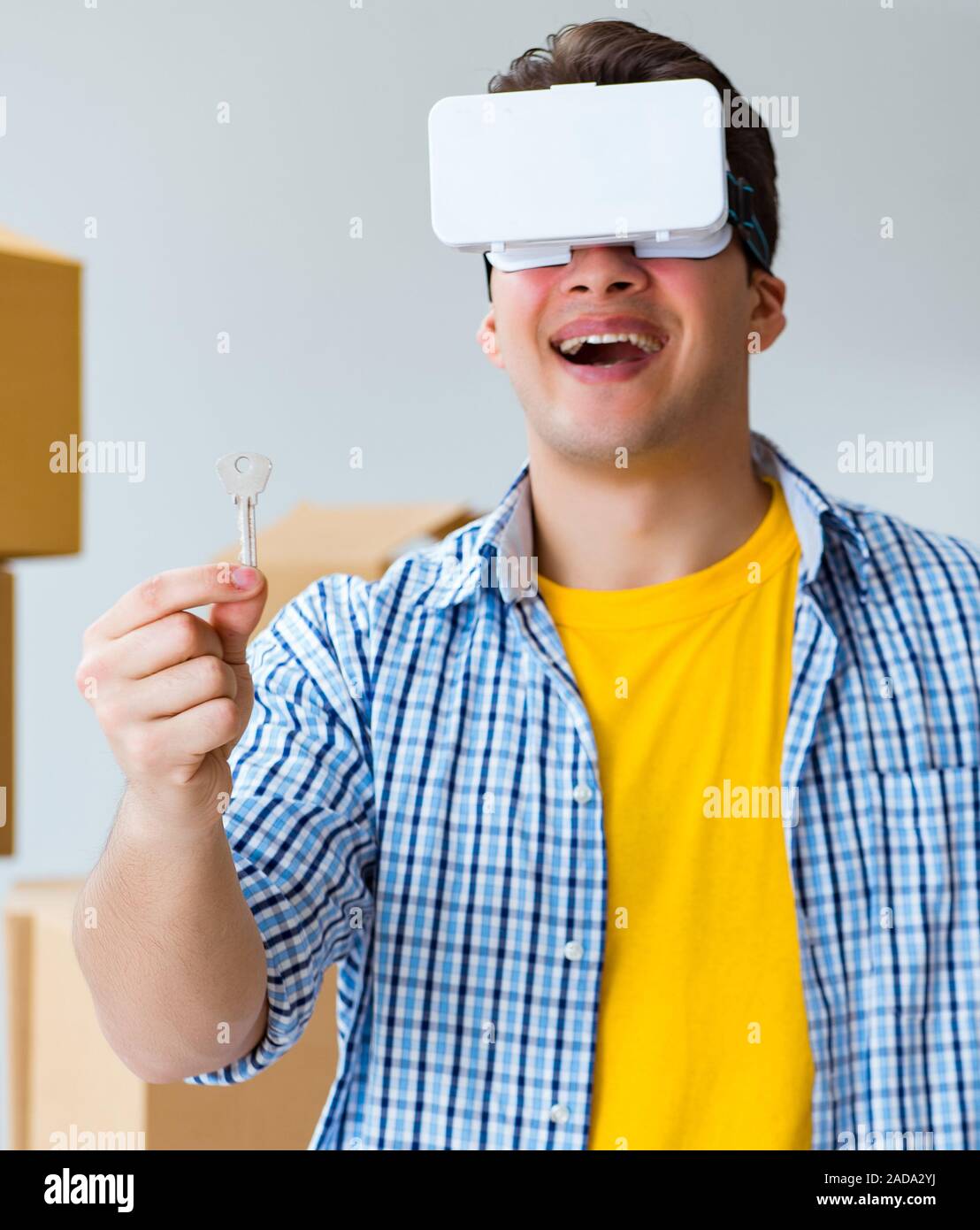Junger Mann mit VR-Brille Umzug in neue Wohnung Stockfoto