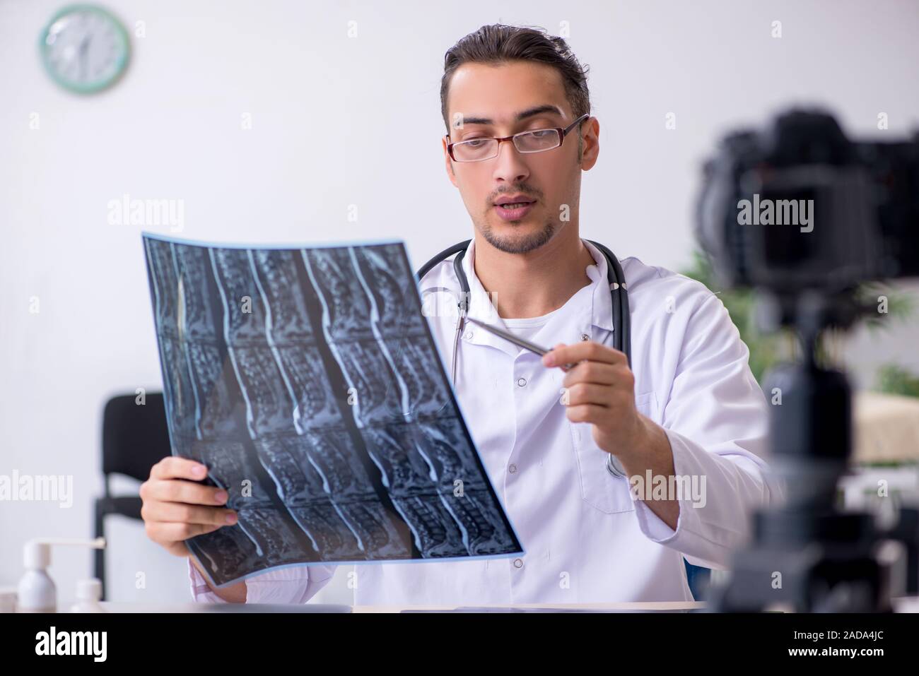 Junge männliche Arzt Radiologe Aufnahme von Video für seinen Blog Stockfoto