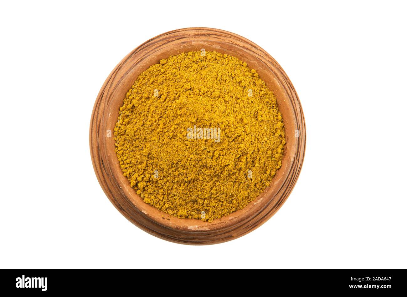 Curry in einem Ton Cup auf einem weißen Hintergrund. Gewürz auf isolieren. Blick von oben. Trockene Gewürze. Stockfoto