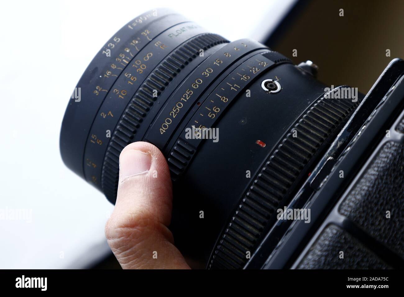 Foto von Blende und Verschlusszeit Einstellring am Objektiv einer alten und vintage Medium format Film Kamera auf einem Stativ. Stockfoto