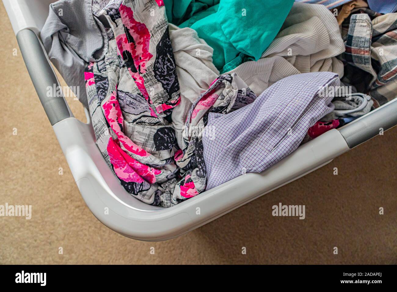 Stapel der Frisch gewaschene Kleidung in die Waschmaschine Warenkorb Stockfoto