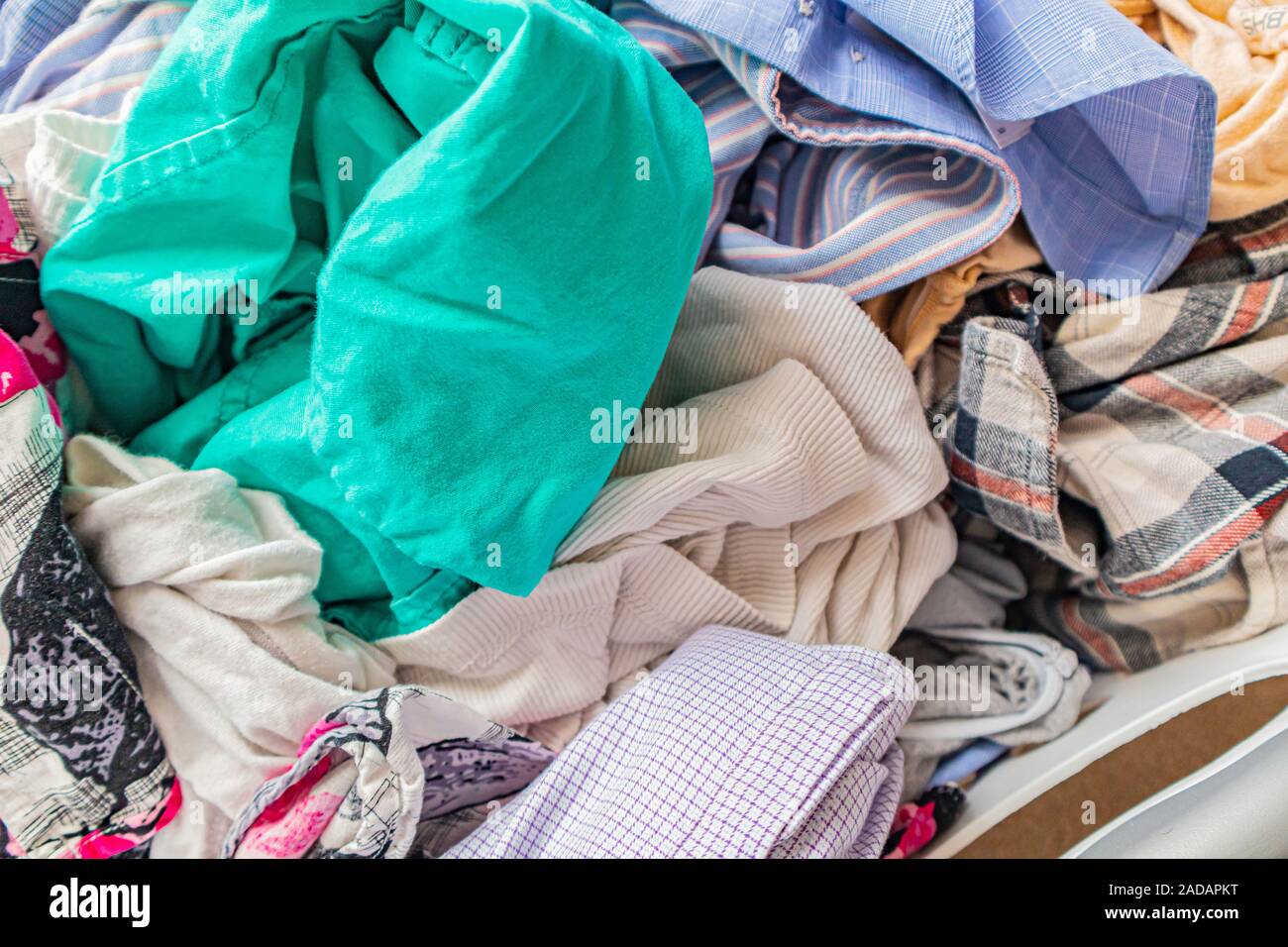 Stapel der Frisch gewaschene Kleidung in die Waschmaschine Warenkorb Stockfoto