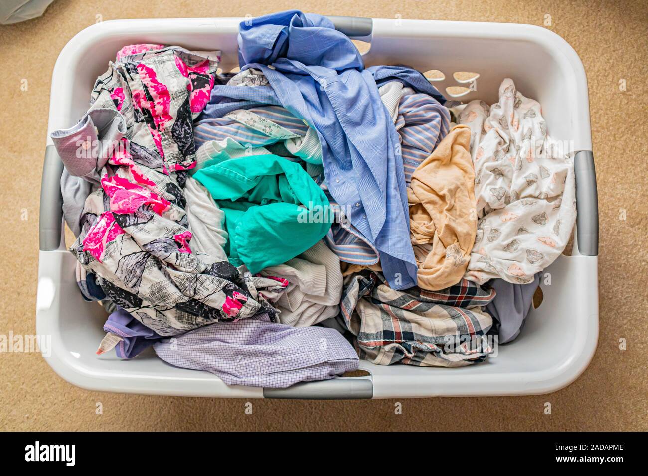 Stapel der Frisch gewaschene Kleidung in die Waschmaschine Warenkorb Stockfoto
