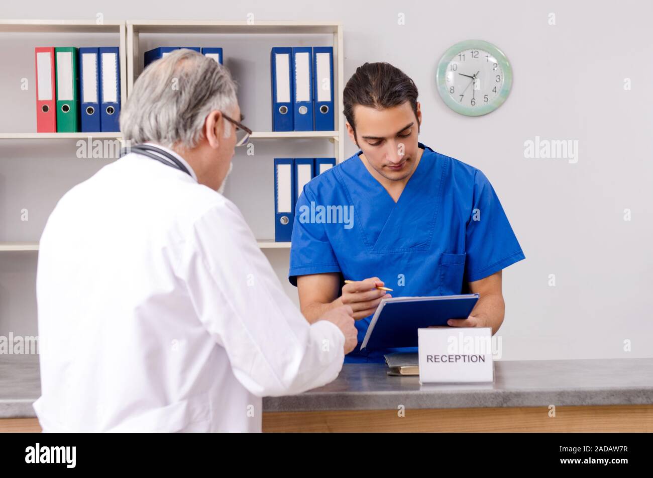 Zwei Ärzte im Gespräch an der Rezeption im Krankenhaus Stockfoto
