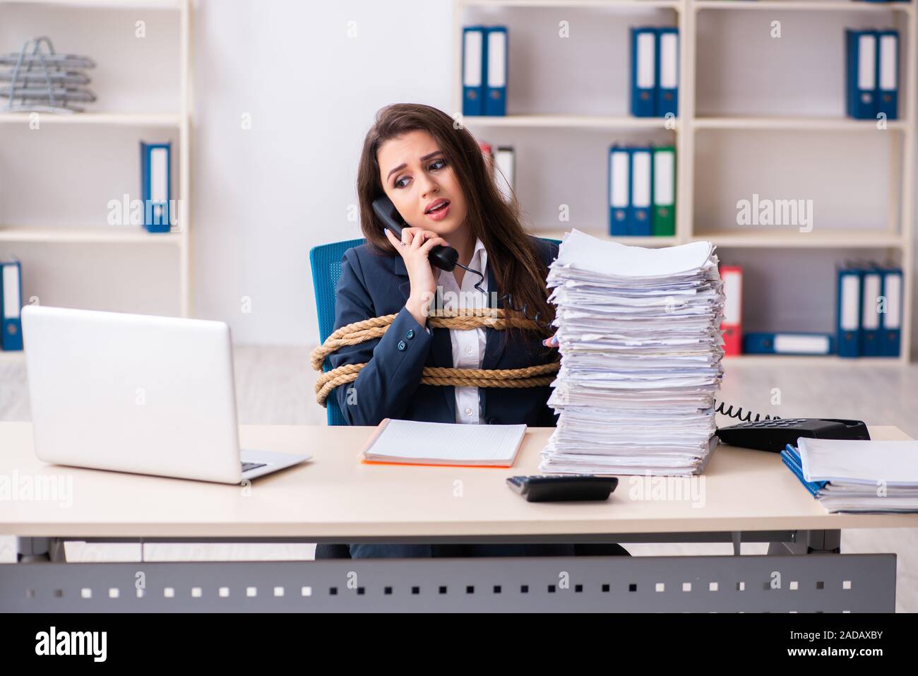 Junge schöne Mitarbeiter gebunden mit Seil im Büro Stockfoto