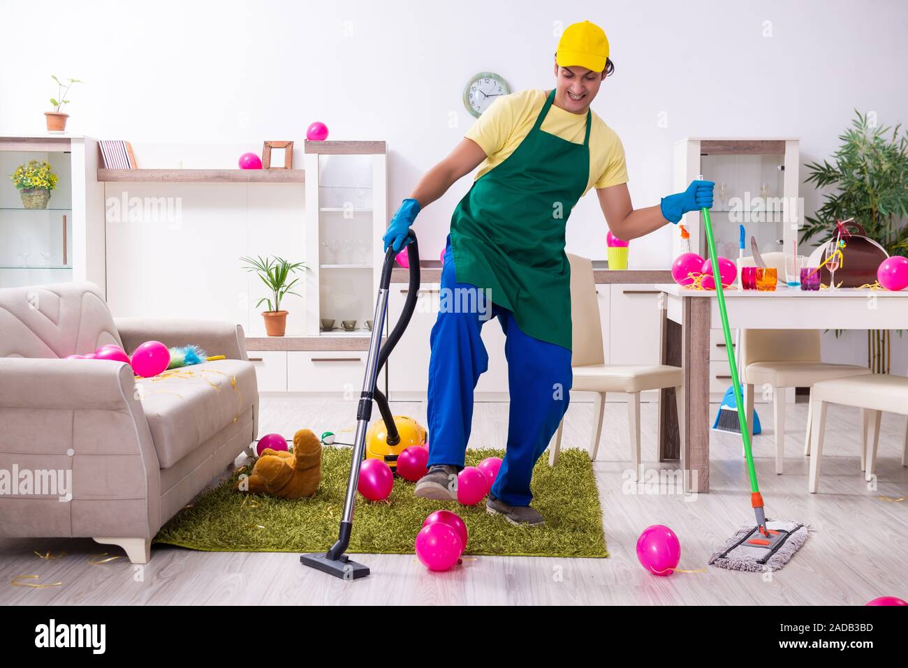 Junge männliche Auftragnehmer tun Hausarbeit nach Partei Stockfoto