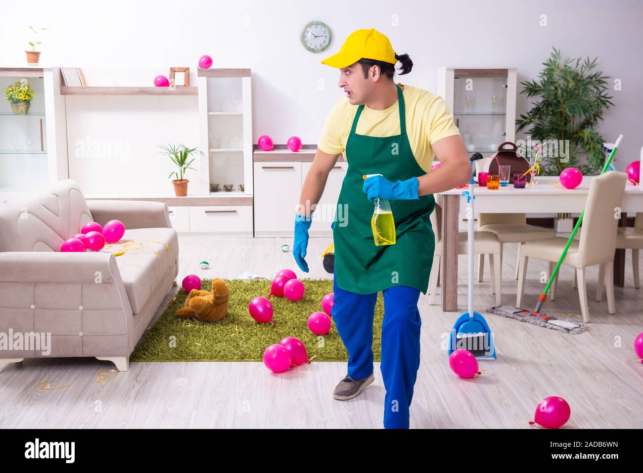 Junge männliche Auftragnehmer tun Hausarbeit nach Partei Stockfoto