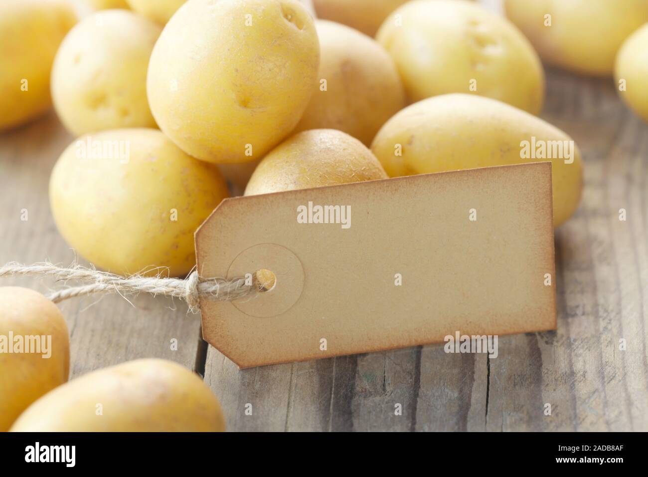 Neue Kartoffeln mit einem Etikett auf einer hölzernen Hintergrund Stockfoto