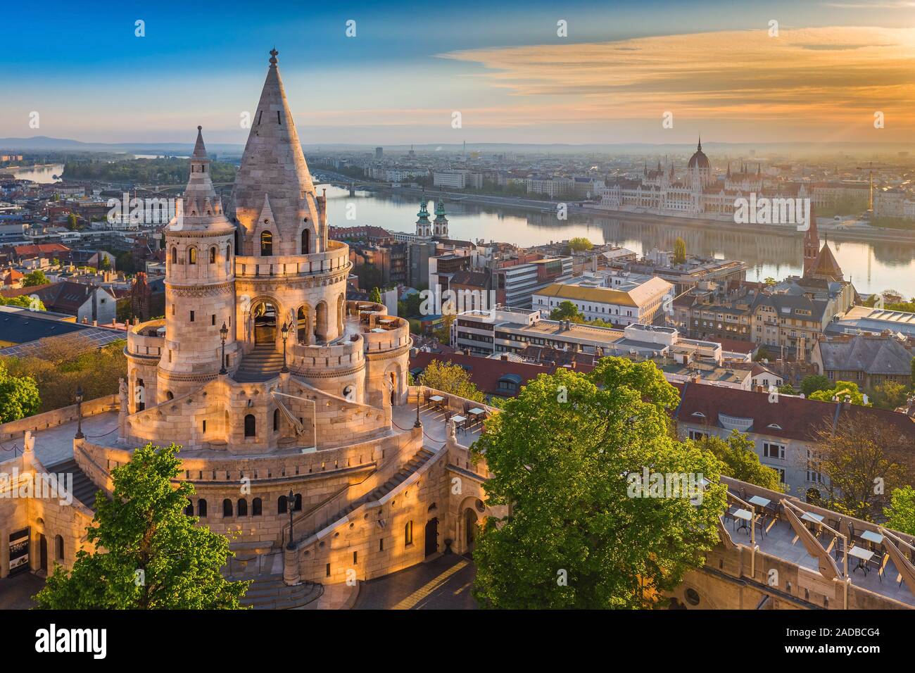 Budapest, Ungarn - schönen goldenen Sommer Sonnenaufgang mit dem Turm von Fisherman's Bastion und grüne Bäume. Das Parlament Ungarns und der Donau bei b Stockfoto