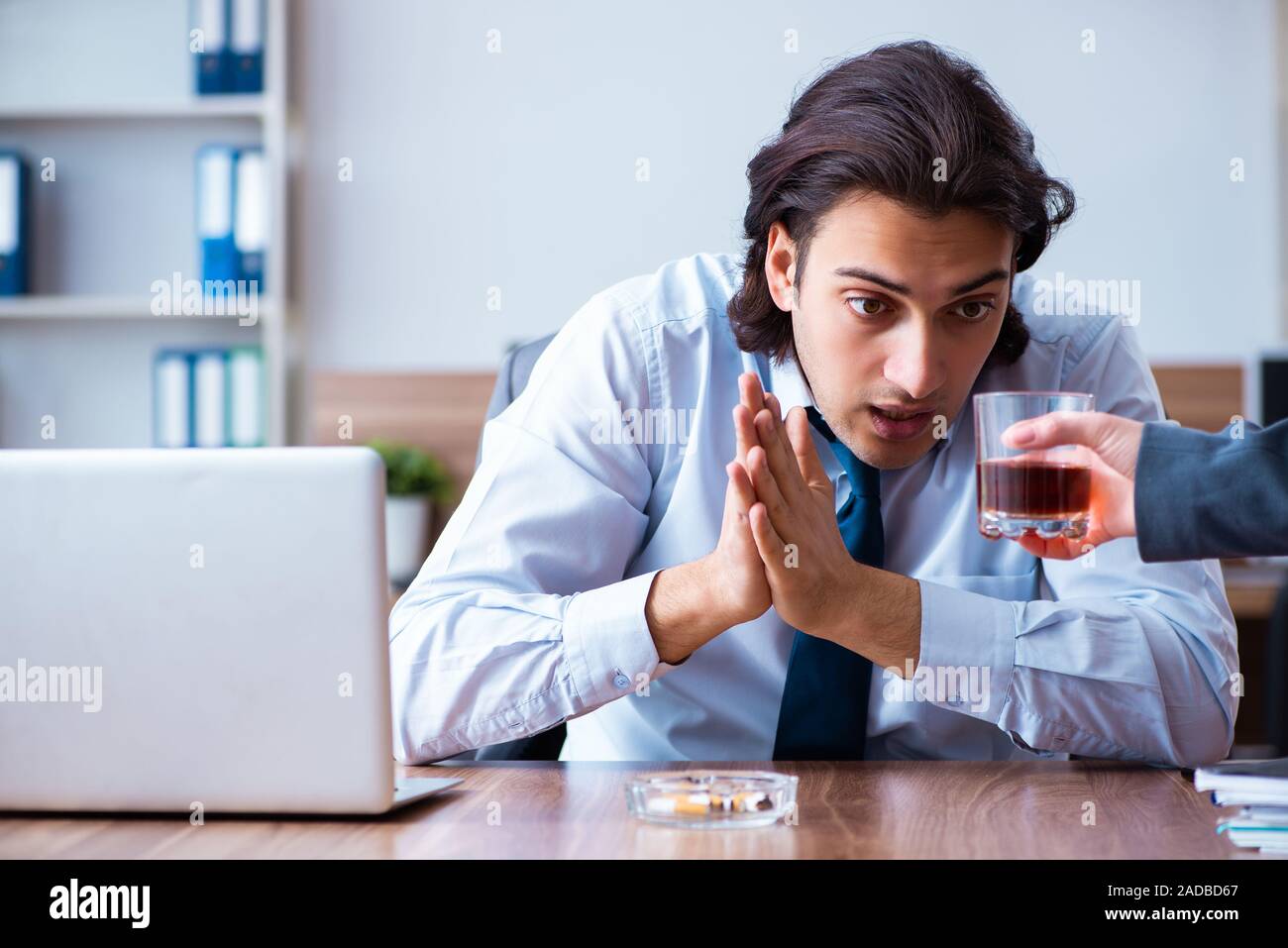 Männliche Mitarbeiter, Alkohol zu trinken und Zigaretten zu rauchen an workpla Stockfoto