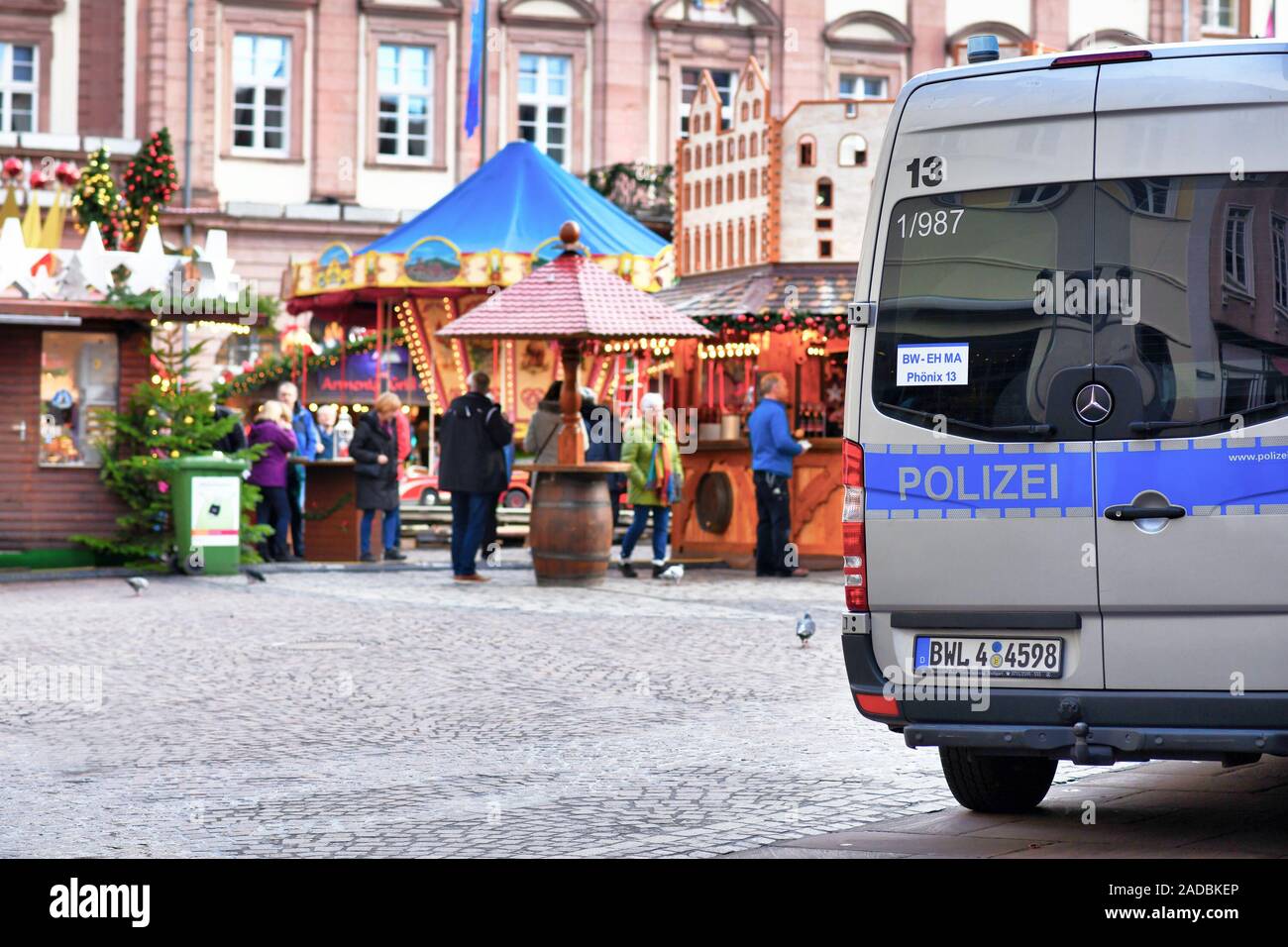 Deutsche Polizei Auto patroling im Stadtzentrum, während der traditionelle Weihnachtsmarkt mit verschwommenen Vertrieb stände und Menschen im Hintergrund Stockfoto