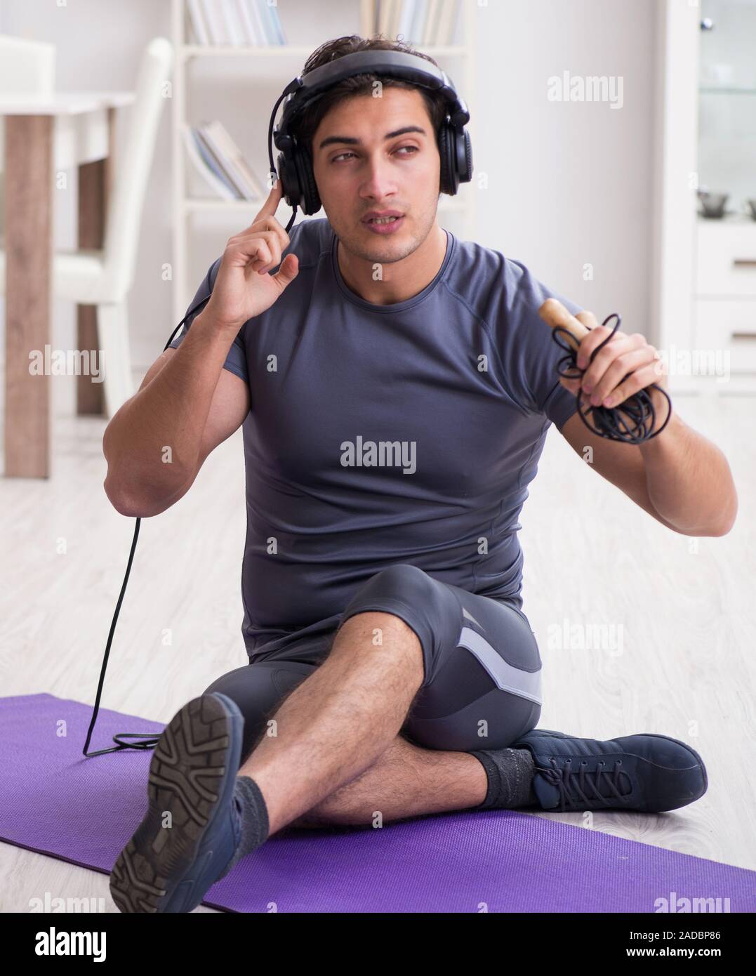 Mann Sport zu Hause und Hören von Musik Stockfoto