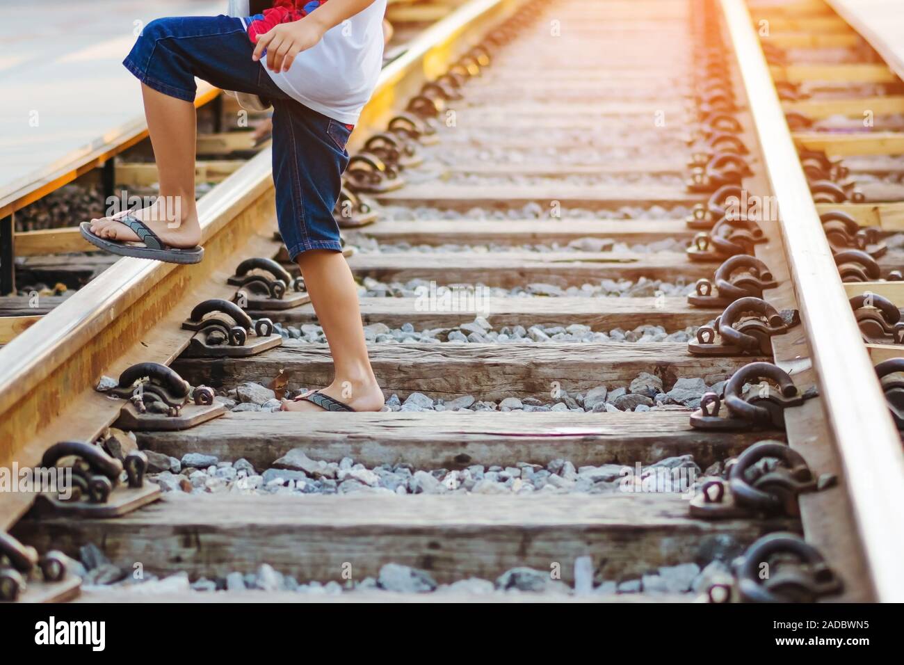 Touristen zu Fuß über Rail Train Tracks von einer Seite zu einer anderen Seite während des Besuchs auf der Brücke über den River Kwai in Kanchanaburi, Thailand. Stockfoto