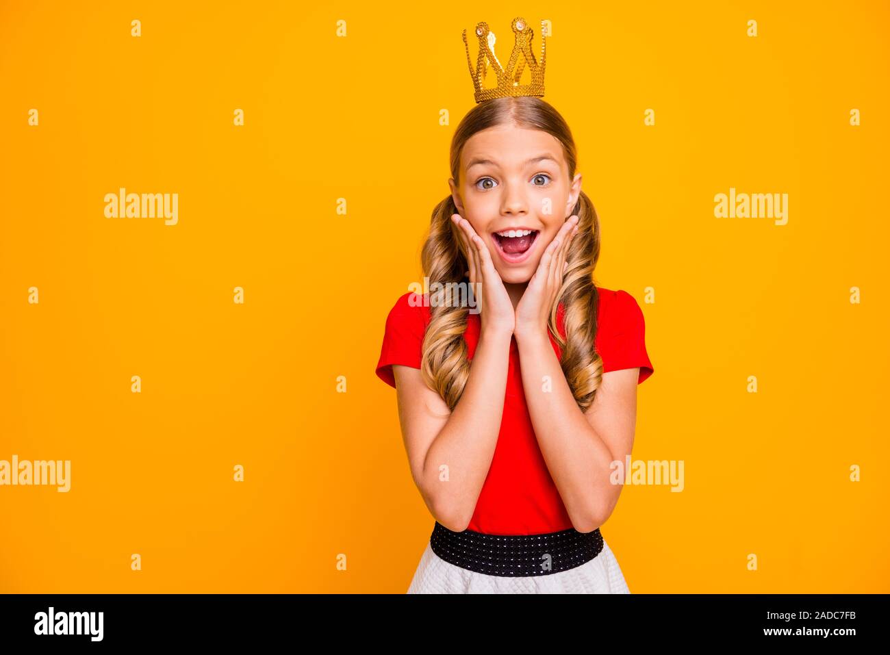 Foto von ziemlich verrückten kleinen Dame königlichen Familie person Arme auf die Wangenknochen Golden Tiara Kopf junge Schule prom Verschleiß casual rot weiß Kleid isoliert Stockfoto