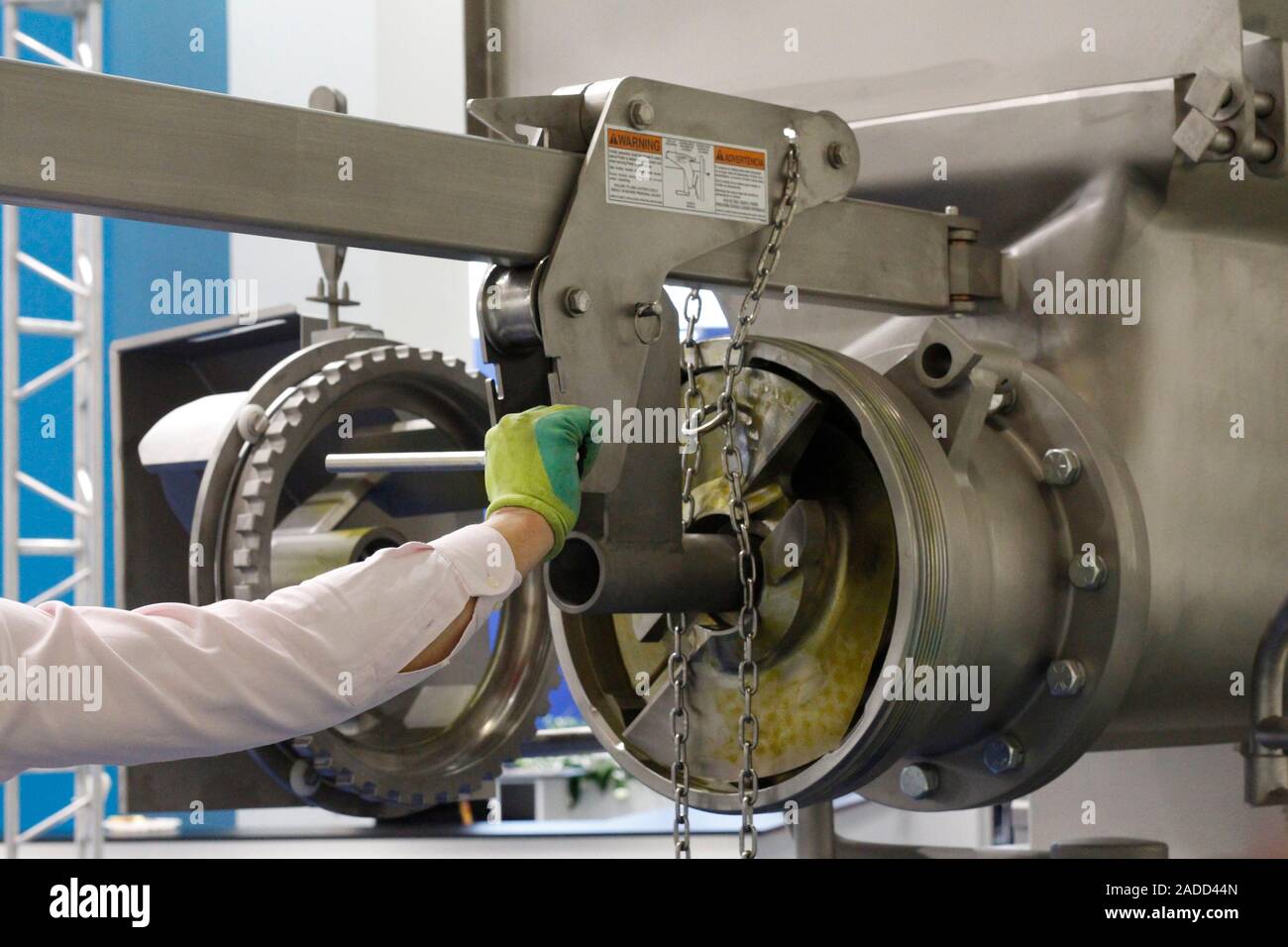 Ein Handwerker ist die Reparatur von doppelseitigem Klebeband in einer Fabrik. Herstellung von Problemen. Mann-master Reparaturen der Produktionslinie. Stockfoto