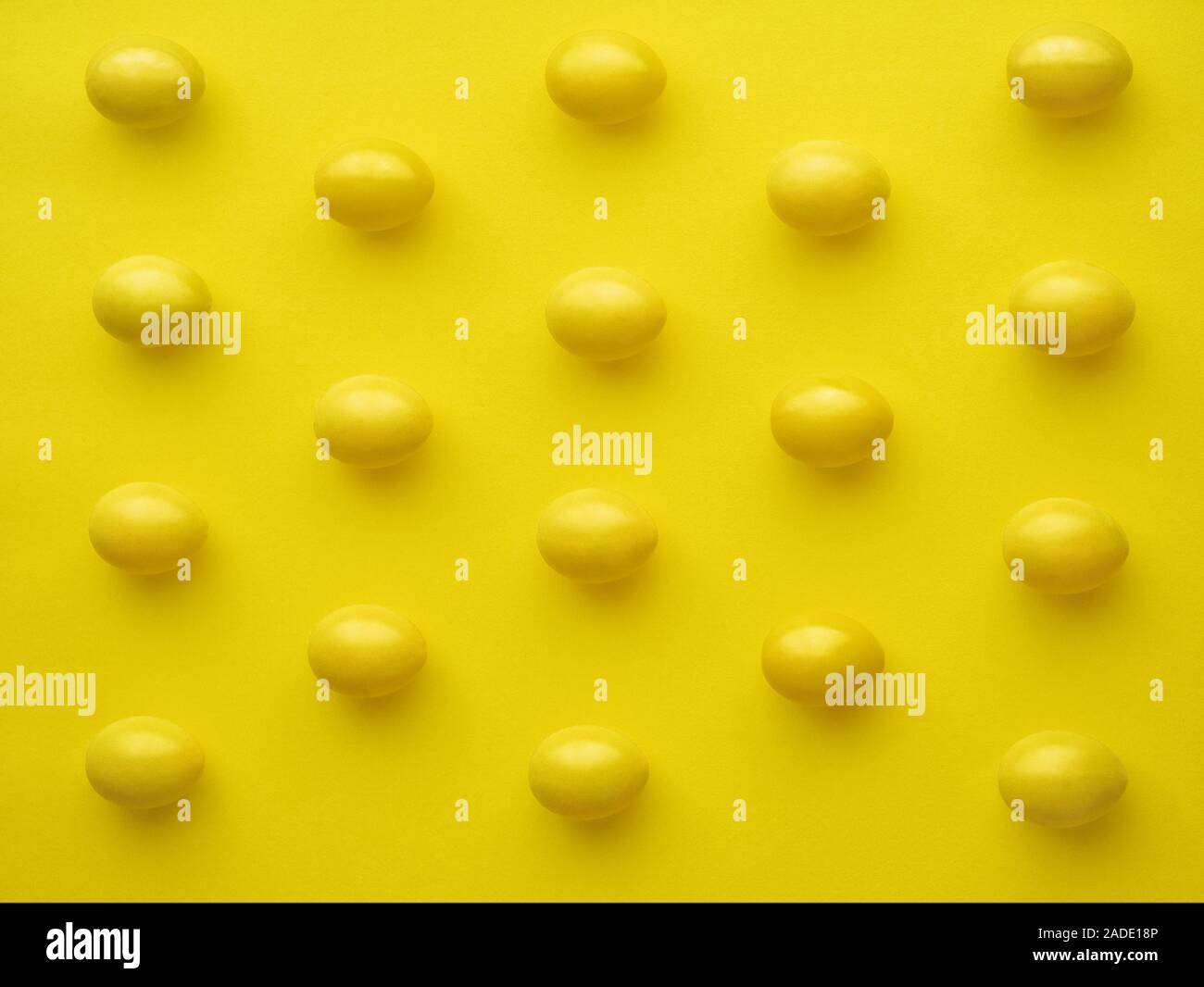 Muster von Hühnereiern in Linie gegen gelben Hintergrund Stockfoto