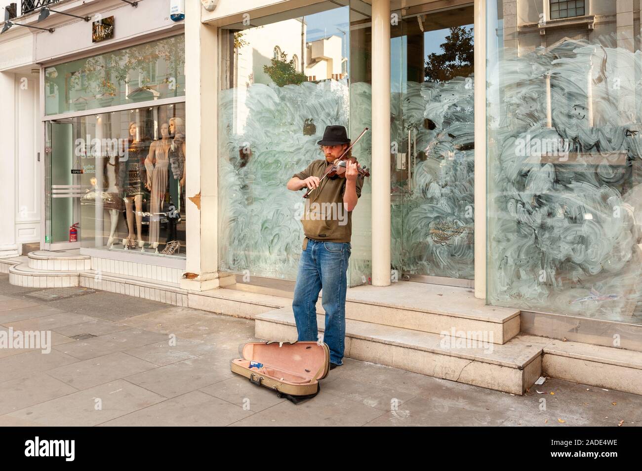 Busker Violine draußen spielen geschlossen Shop auf der King's Road, Chelsea, London, UK Stockfoto