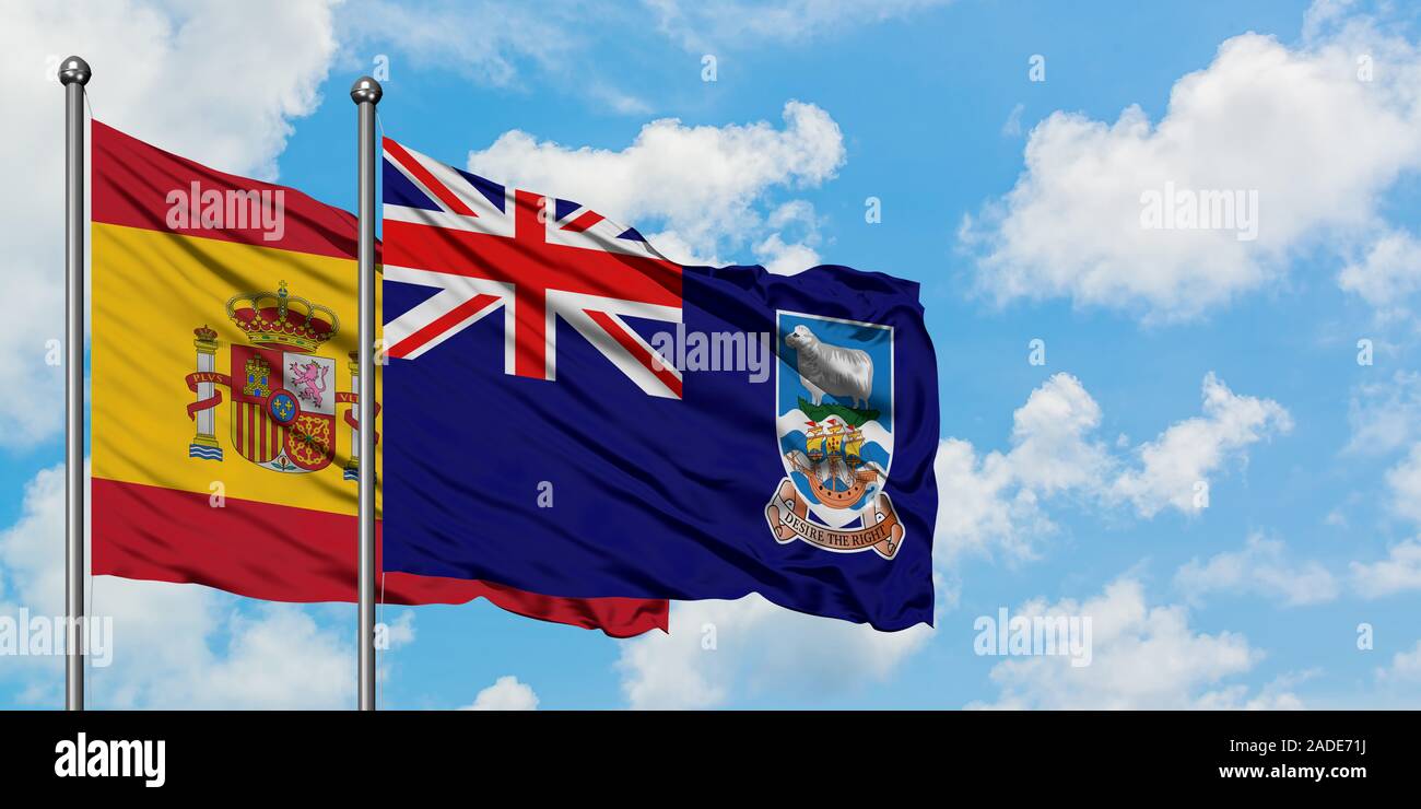 Spanien und Falkland Inseln Flagge im Wind gegen Weiße bewölkt blauer Himmel zusammen. Diplomatie Konzept, internationale Beziehungen. Stockfoto