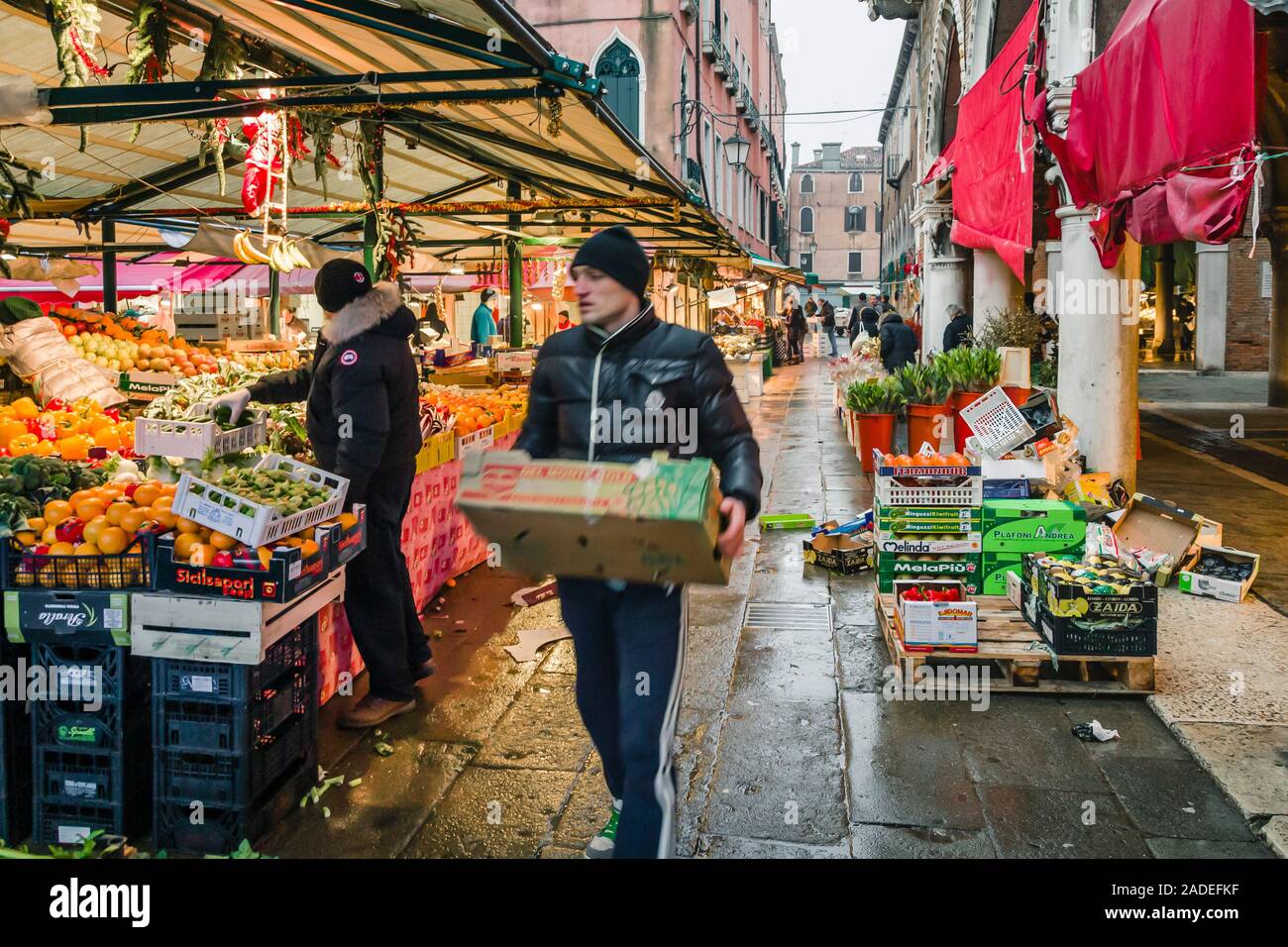 Venedig, Italien - 24. Dezember 2012. Der Händler trägt Kisten mit Gemüse zu einem traditionellen europäischen Börse zu den Mercato di Rialto, Veni Abschaltdruck Stockfoto