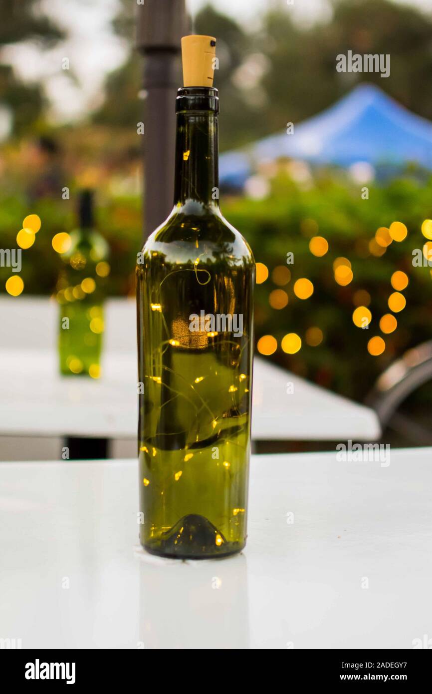 Abstrakte grüne Wein Glas Flasche mit Lichterketten innen Stockfoto