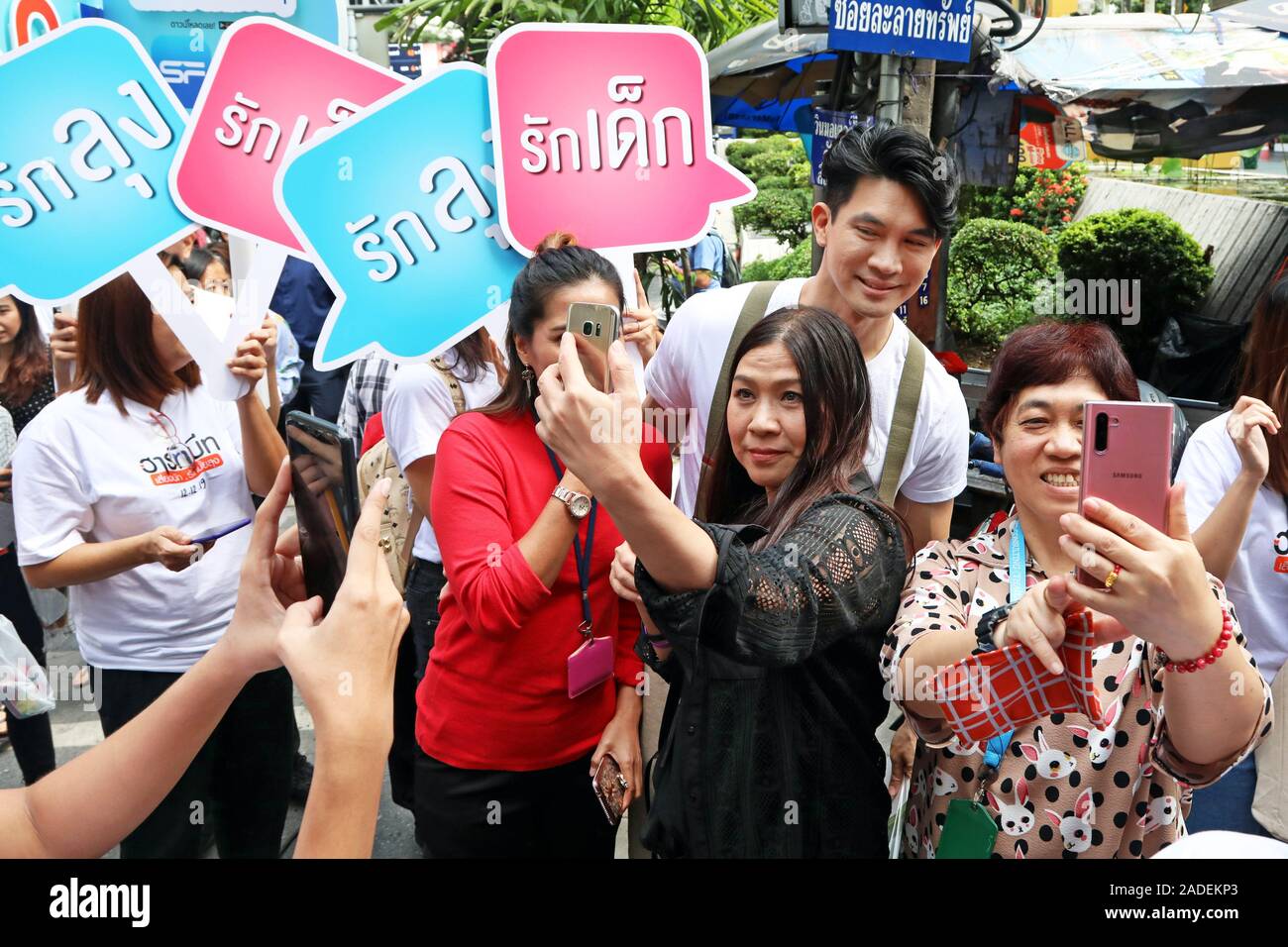 Bangkok, Thailand. 4. Dez, 2019. Beliebte thailändische Schauspieler Theeradej Wongpuapan (Kane) wird gemobbt für selfies durch verehrenden Fans, als er seinen neuesten Film Herzschläge in der Silom Bangkok fördert. Er Fans begrüßt, und gab ihnen viel Zeit, Fotos zu sich zu nehmen, als er sich der Silom Straße gelaufen und später durch einen lokalen Markt, wo er grüßte Inhaber Stall ging. Heartbeats ist am 12. Dezember veröffentlicht. Quelle: Paul Brown/Alamy leben Nachrichten Stockfoto