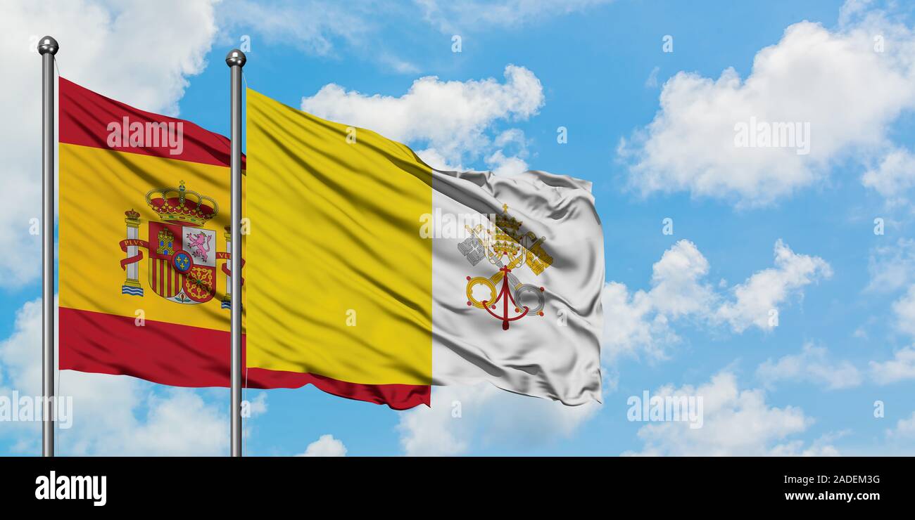 Spanien und Vatikanstadt Flagge im Wind gegen Weiße bewölkt blauer Himmel zusammen. Diplomatie Konzept, internationale Beziehungen. Stockfoto